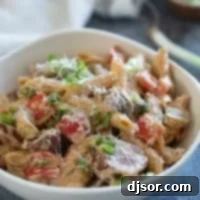 Hearty Cajun Sausage Pasta 9 Bowl filled with Cajun Sausage Pasta topped with parmesan cheese.