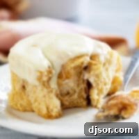 Sweet Potato Cinnamon Roll with a piece taken from it on a plate.