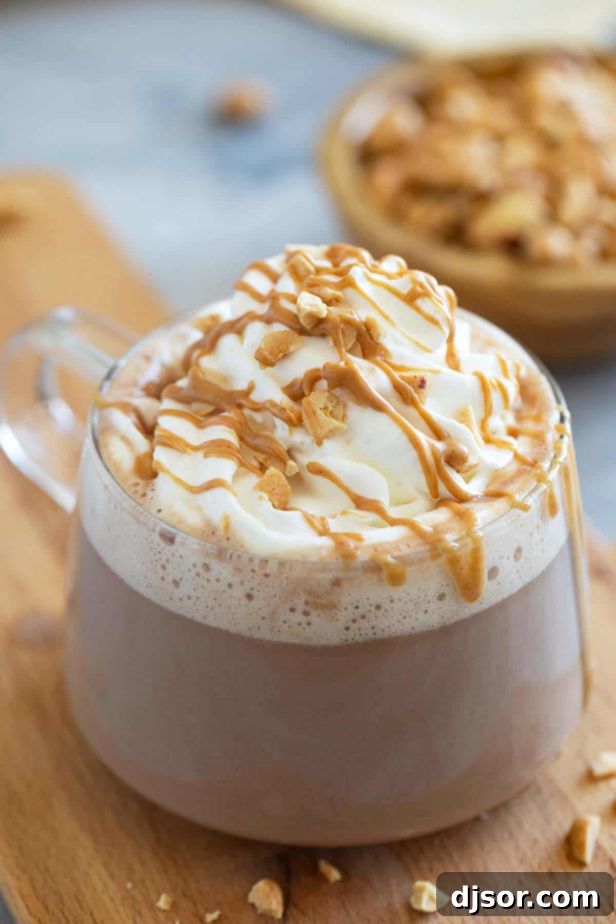 Peanut Butter Chocolate Bliss 5 Glass mug with peanut butter hot chocolate, topped with whipped cream.