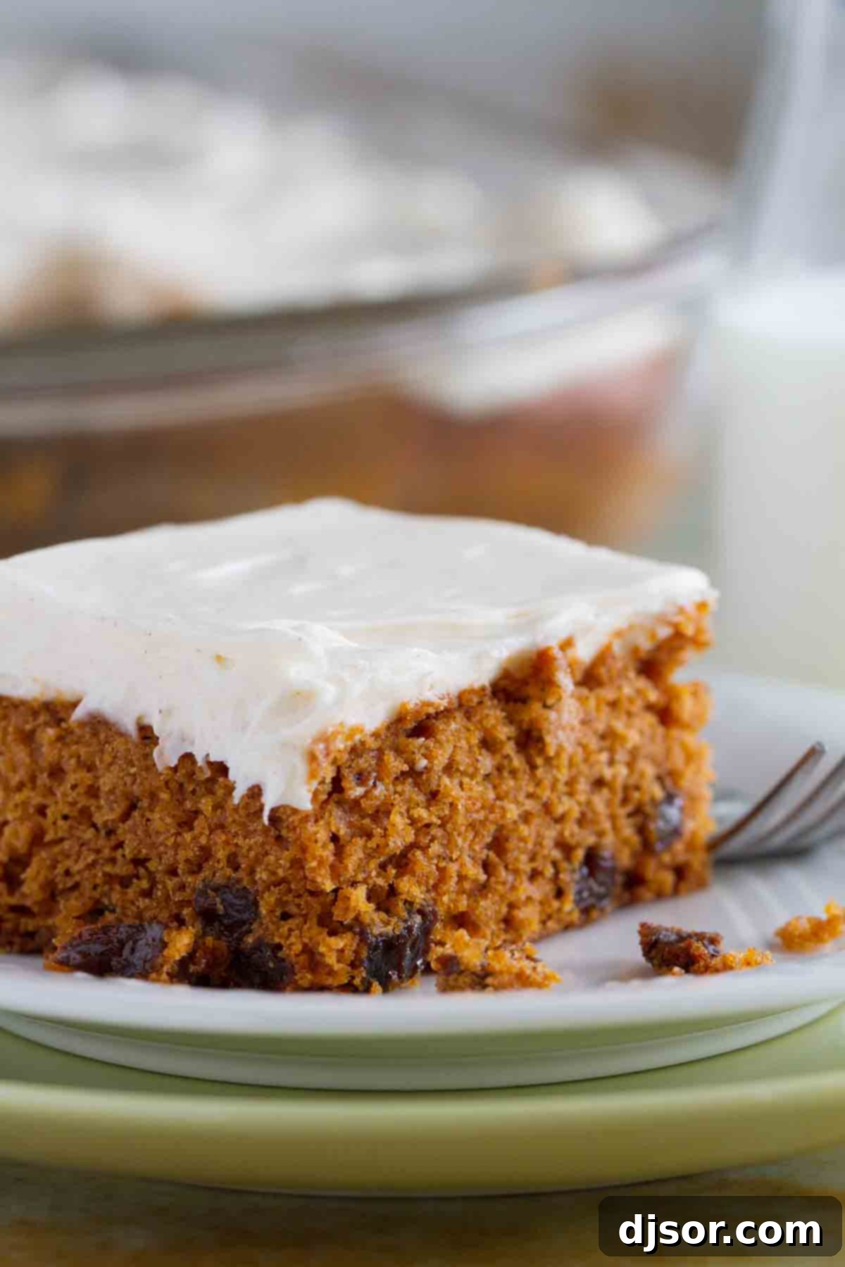 Slice of Tomato Soup Spice Cake topped with creamy cream cheese frosting, ready to be enjoyed.