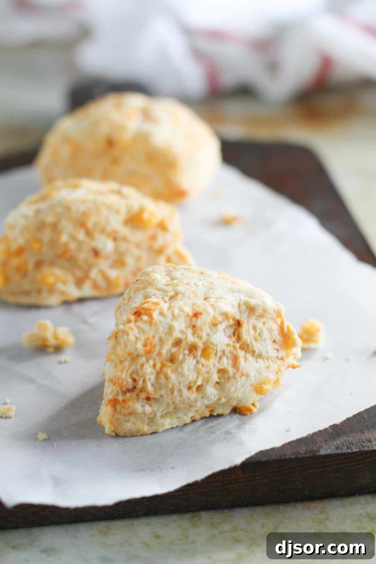 Chipotle Cheddar Scones cooling on a cutting board lined with parchment paper, highlighting their rustic charm.