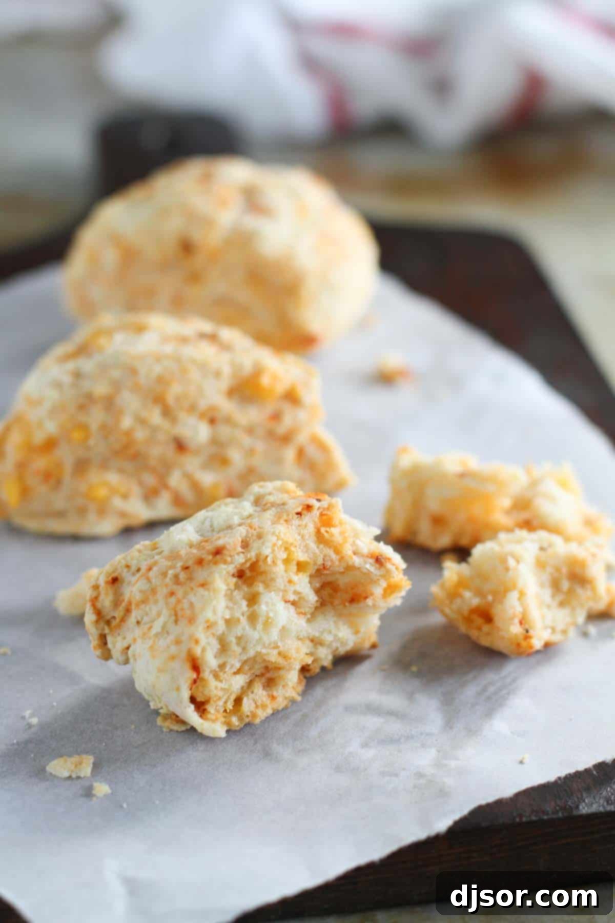 A Chipotle Cheddar Scone broken in half, revealing its soft, fluffy interior filled with melted cheddar and flecks of chipotle.