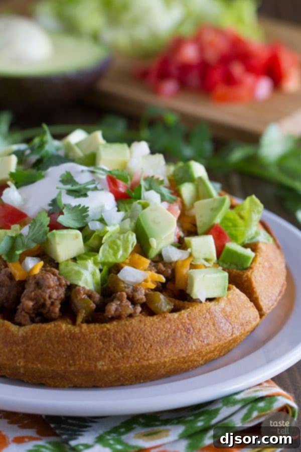 Savory Taco Cornbread Waffles topped with ground beef and fresh taco fixings, perfect for a fun and easy taco night twist.