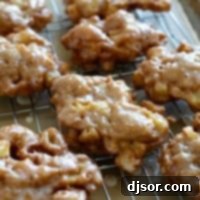 Golden Apple Delights 10 Glazed Apple Fritters on a cooling rack over parchment paper.