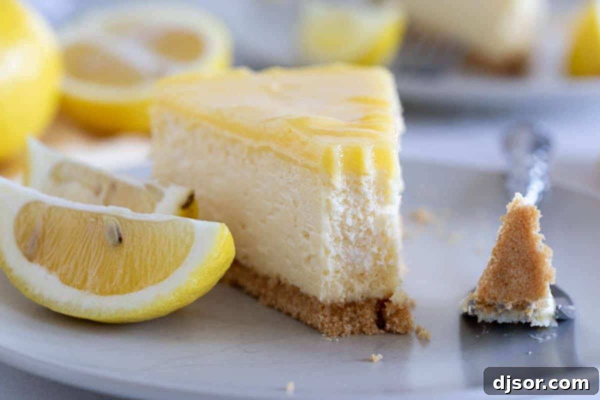 A fork holding a perfect bite of Lemon Cheesecake, highlighting the creamy texture, crunchy crust, and the bright lemon curd topping.
