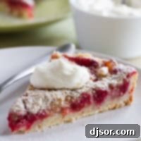 Golden Pear and Raspberry Tart 6 Slice of pear and raspberry tart, topped with whipped cream.