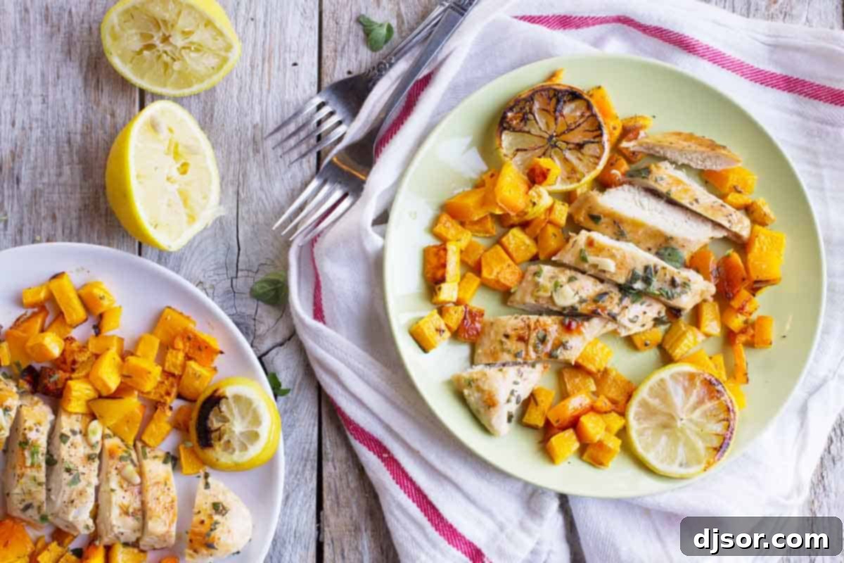 Easy Lemon Chicken with Roasted Butternut Squash Two plates featuring beautifully roasted lemon chicken alongside tender butternut squash, garnished with fresh herbs and lemon slices.