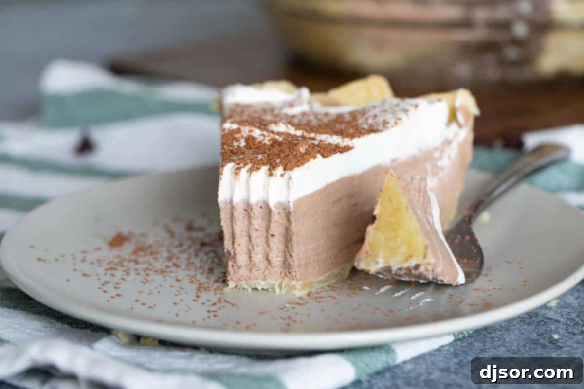 Enjoying a Bite of Perfectly Creamy Chocolate Pie A slice of chocolate cream pie with a bite taken, showcasing the smooth filling and fluffy topping.