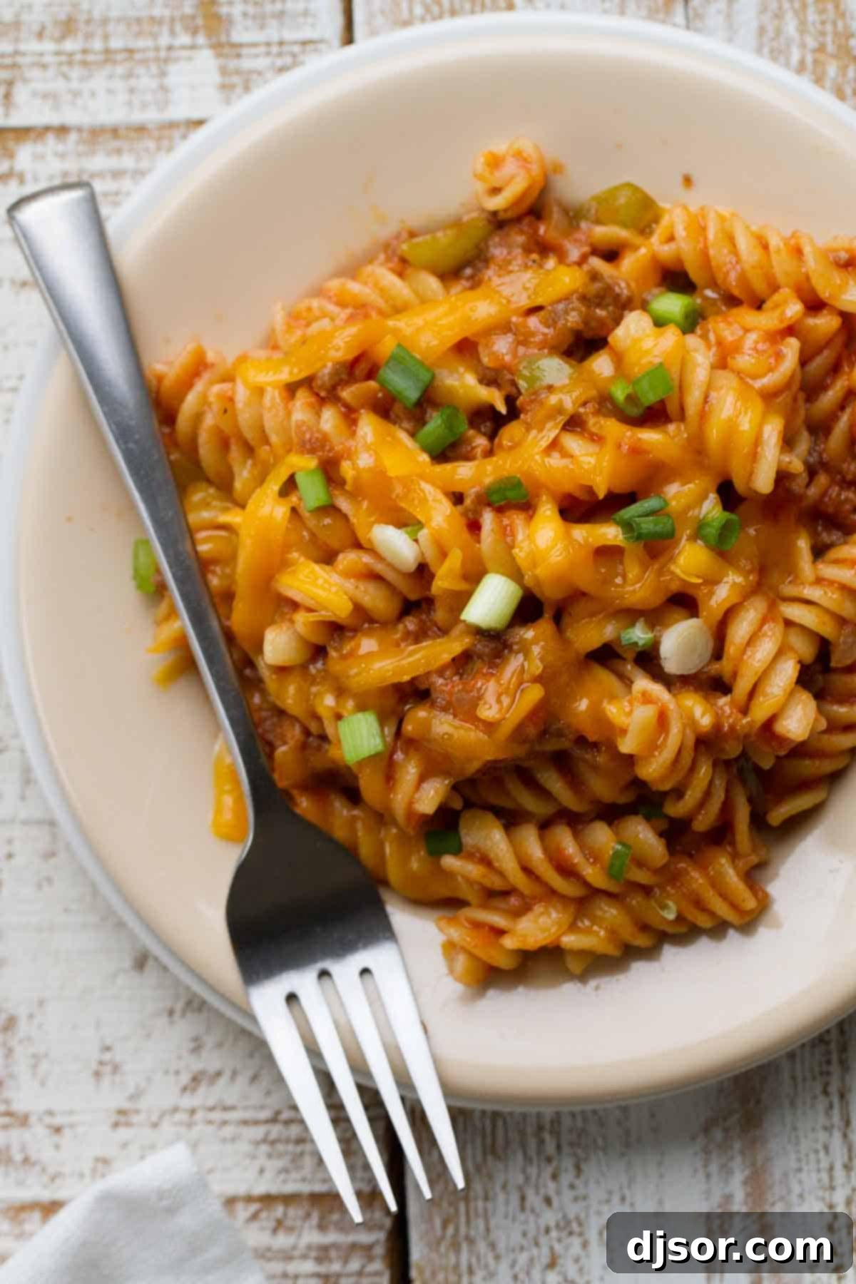 Plate and fork full of Sloppy Joe Pasta, showcasing the rich sauce and melted cheese.