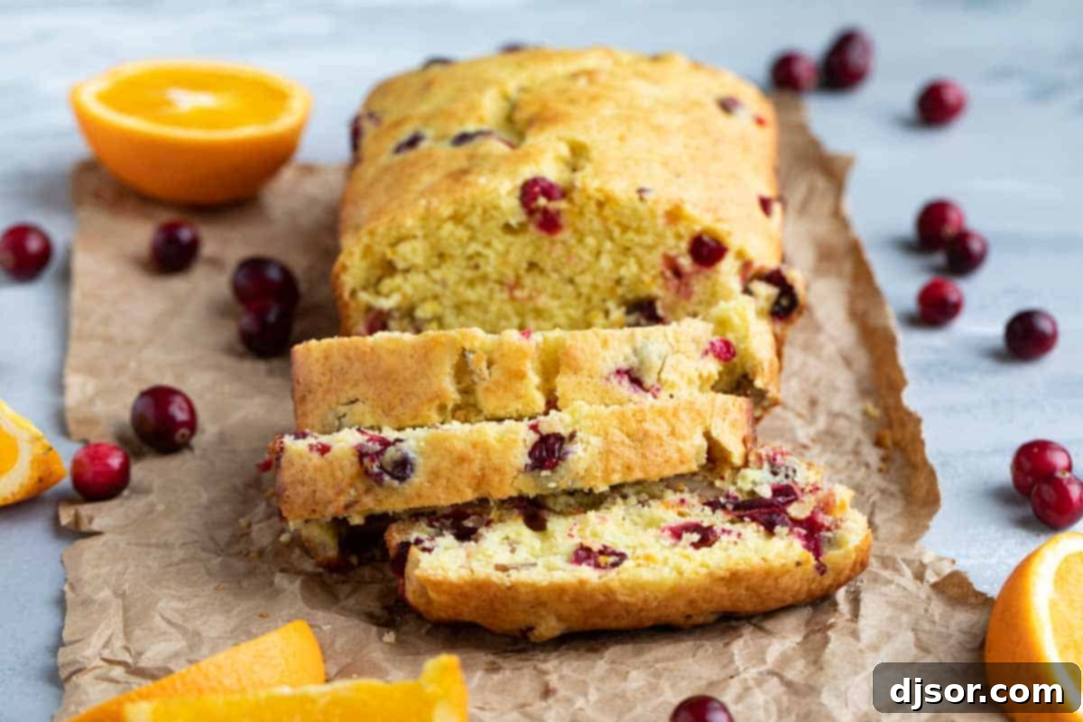loaf of sliced cranberry orange bread, showcasing its vibrant color and tender crumb