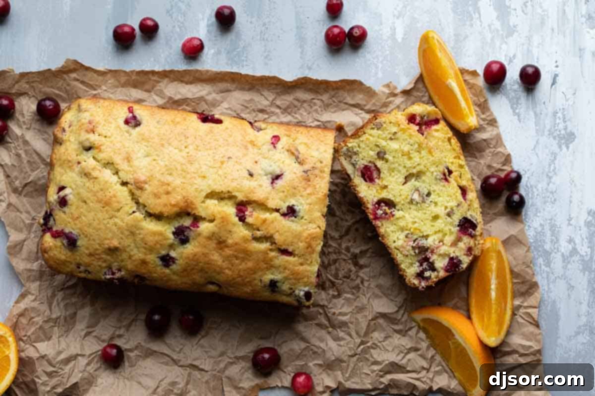 sliced loaf of cranberry orange bread showing the tender crumb and distributed cranberries
