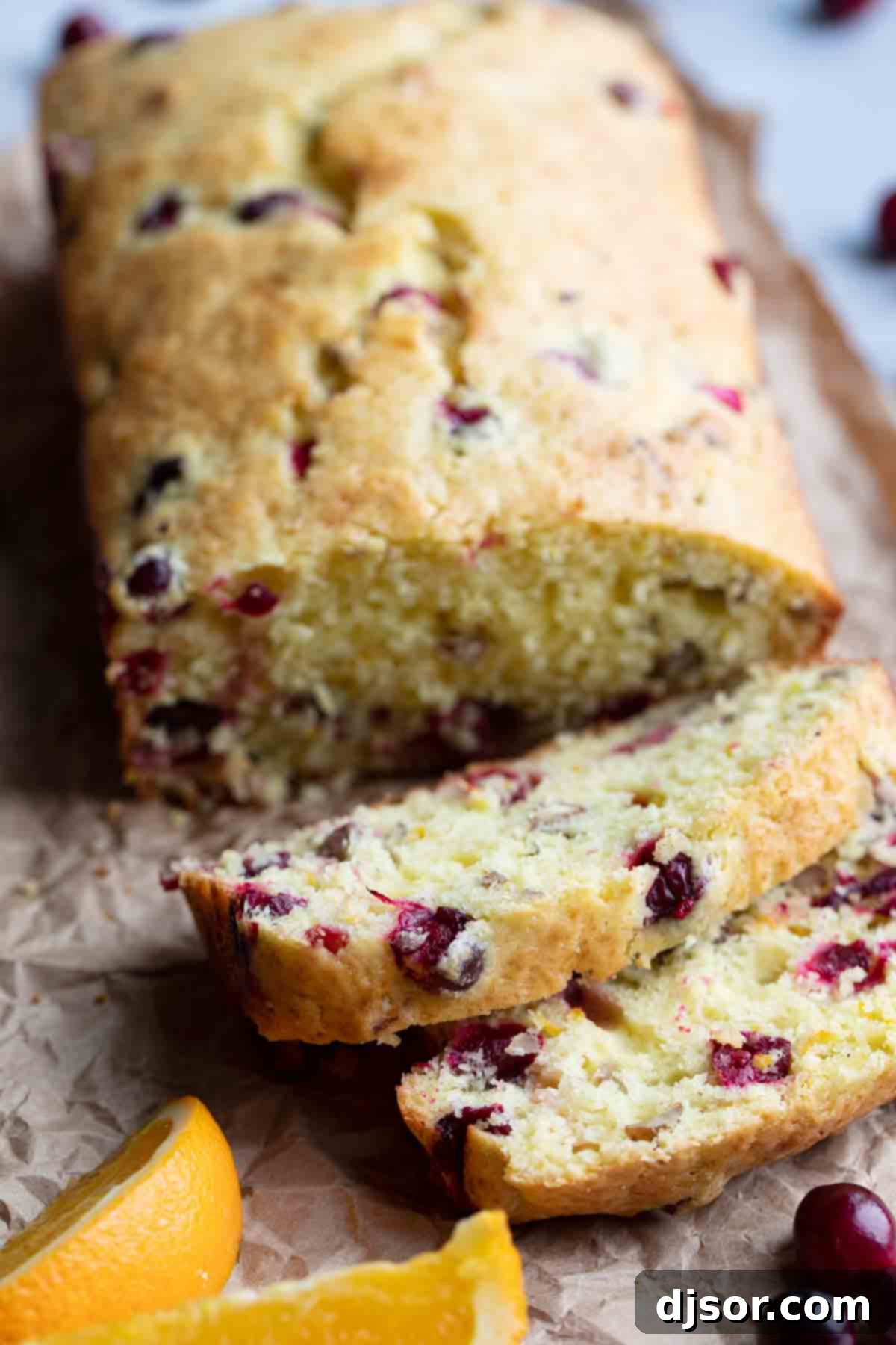 slices of cranberry orange bread beautifully arranged with fresh cranberries as garnish