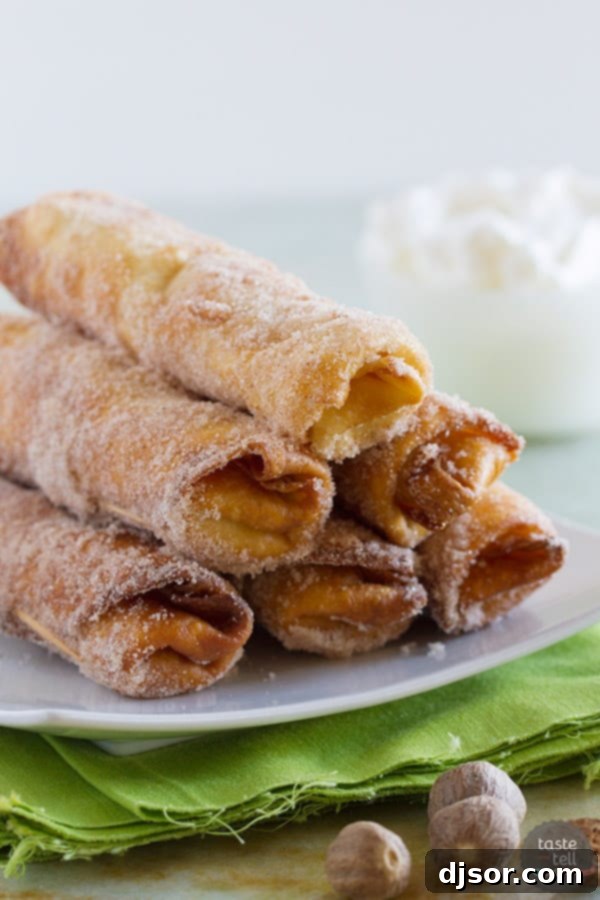 A plate of freshly fried Eggnog Empanadas, ready to be served with whipped cream.