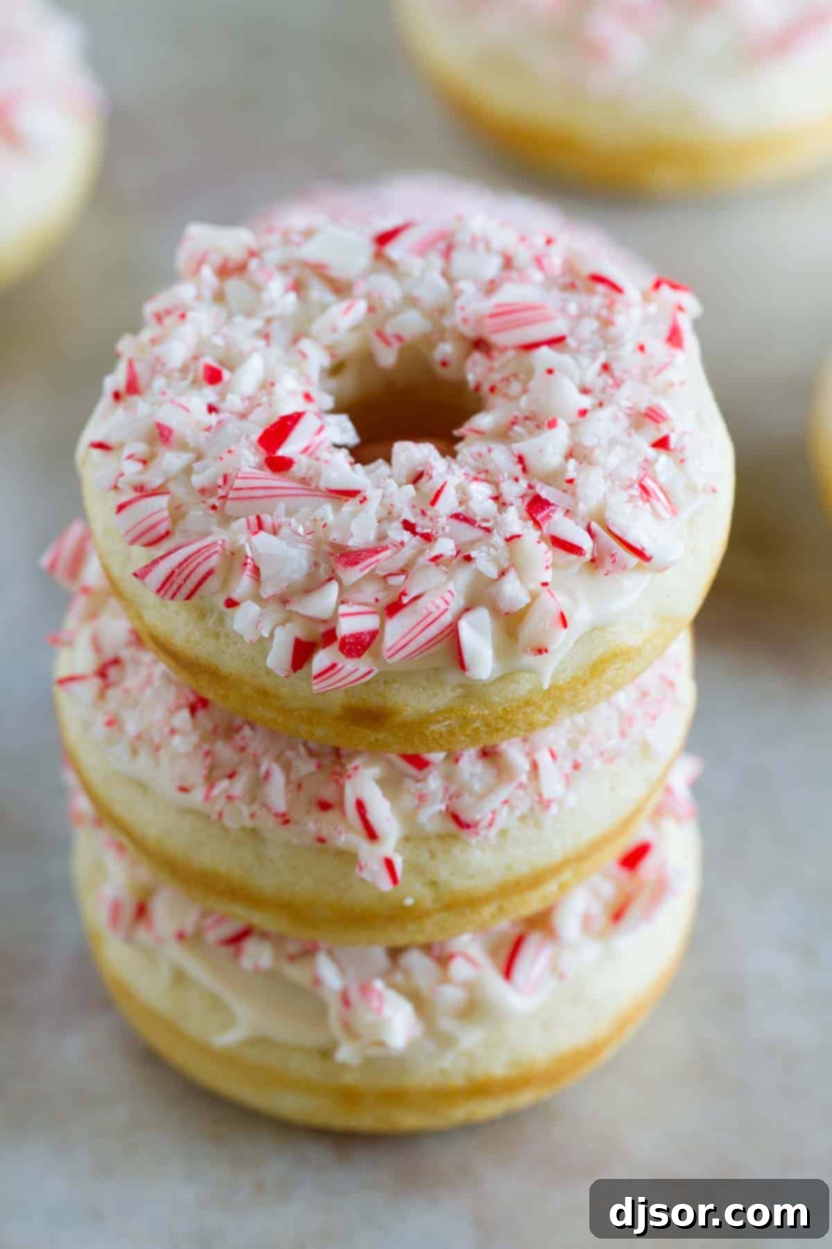 Three baked peppermint donuts stacked on top of each other, ready to be enjoyed.