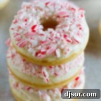 Three baked peppermint donuts stacked on top of each other, ready for serving.