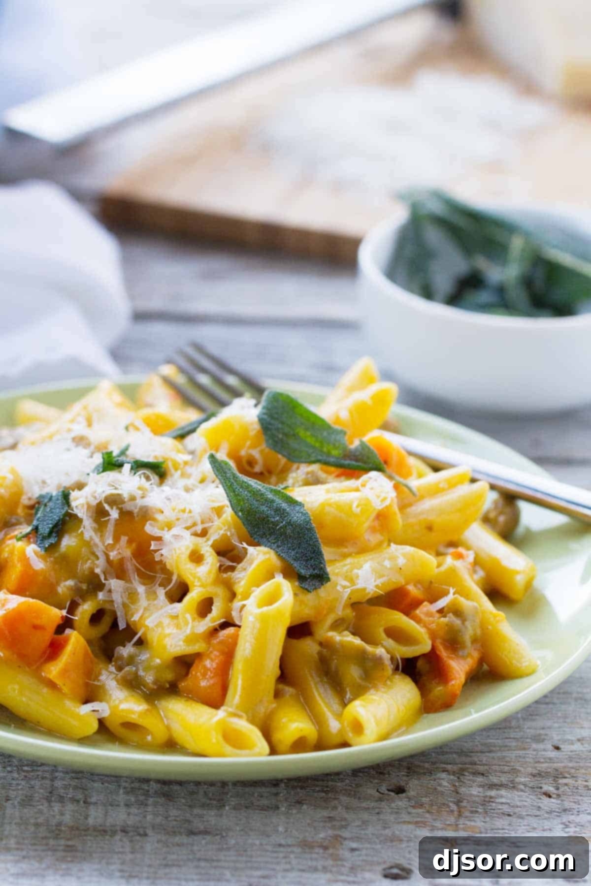 Serving of Penne with Butternut Squash and Sausage on a plate.