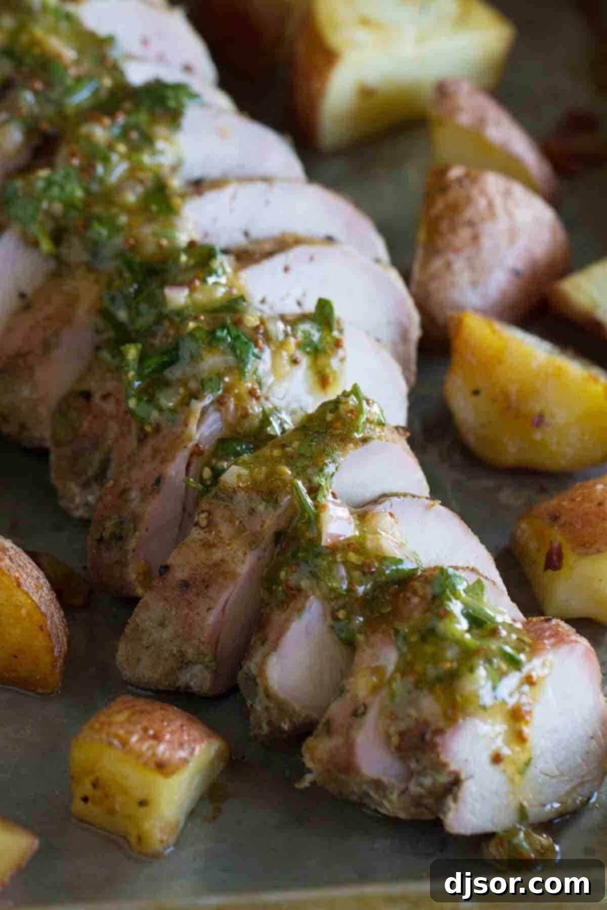 Tender slices of roasted pork tenderloin, beautifully topped with a creamy, tangy mustard sauce and served alongside perfectly roasted baby red potatoes, creating a complete and satisfying meal.