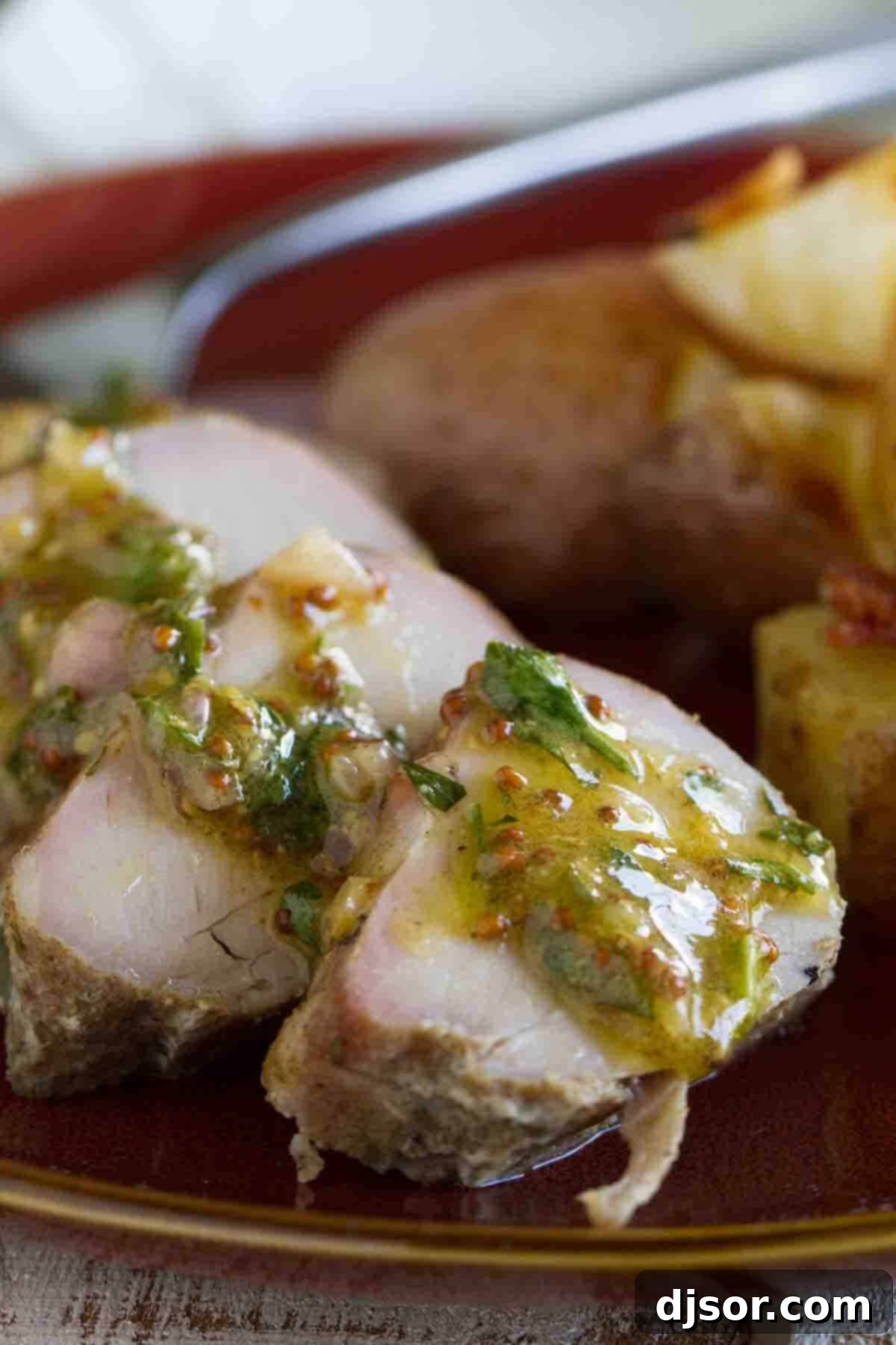 Close-up of perfectly roasted pork tenderloin slices, artfully arranged and generously drizzled with a rich, vibrant mustard sauce, showcasing the dish's delicious appeal.