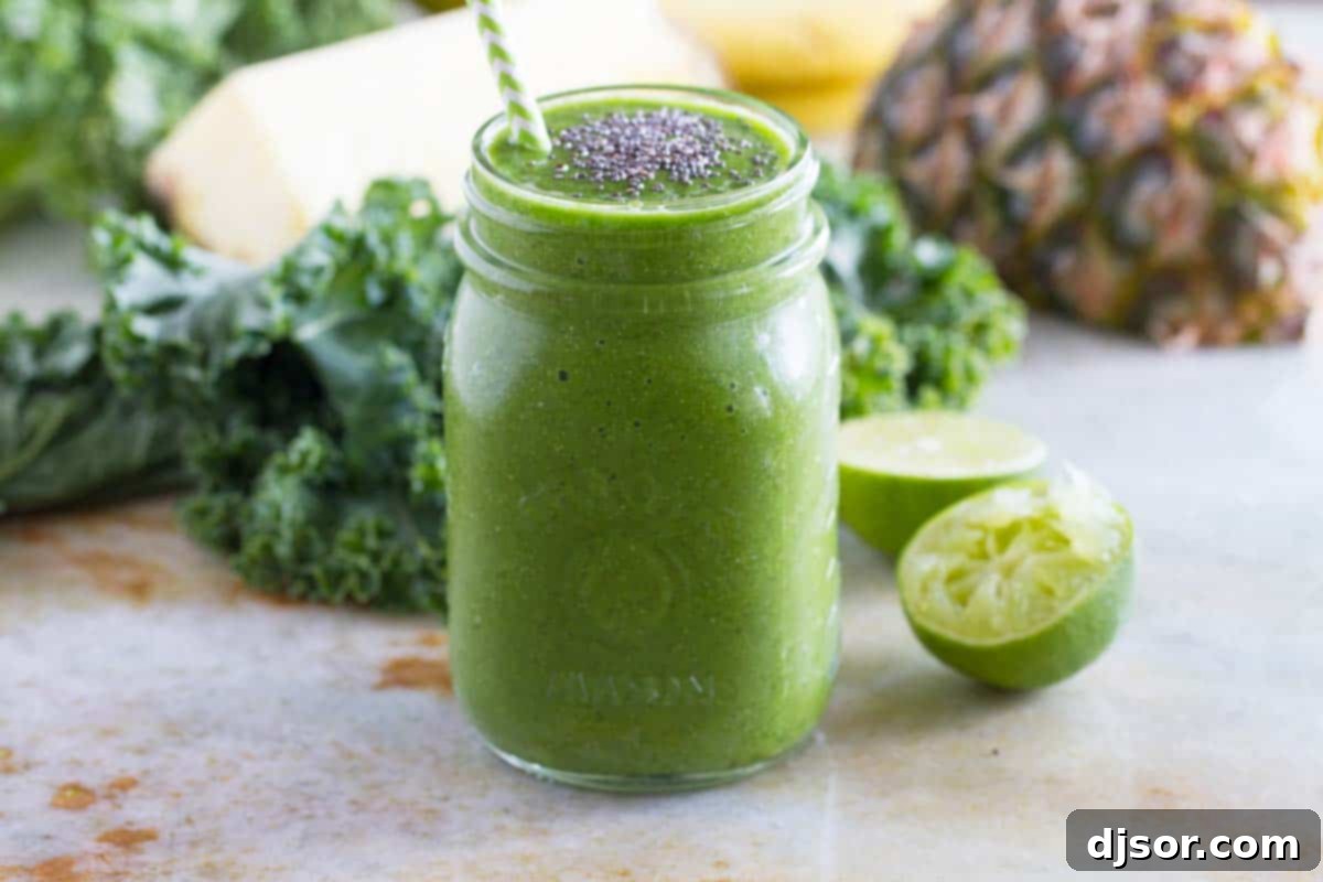 A delicious green smoothie recipe packed with iron, potassium, and fiber. Vibrant Kale Smoothie topped with chia seeds, with fresh fruit and kale leaves artfully arranged in the background, highlighting the healthy ingredients.