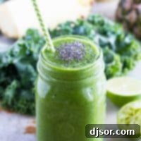 Kale Pineapple Banana Smoothie 2 A vibrant green kale smoothie with a straw and chia seeds in a jar, ready to be enjoyed.