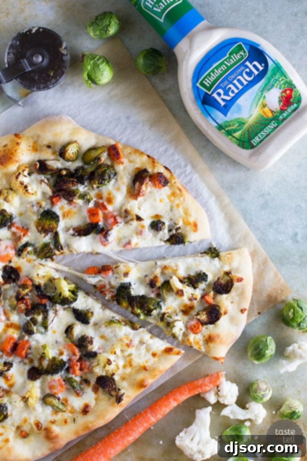 A slice of Roasted Vegetable Pizza with Ranch, showcasing golden crust, melted cheese, and tender roasted veggies.