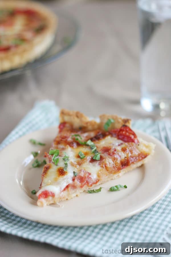 A buttery, flaky crust is filled with fresh tomatoes, bacon and lots of cheese for the perfect end of summer Tomato Tart Recipe.