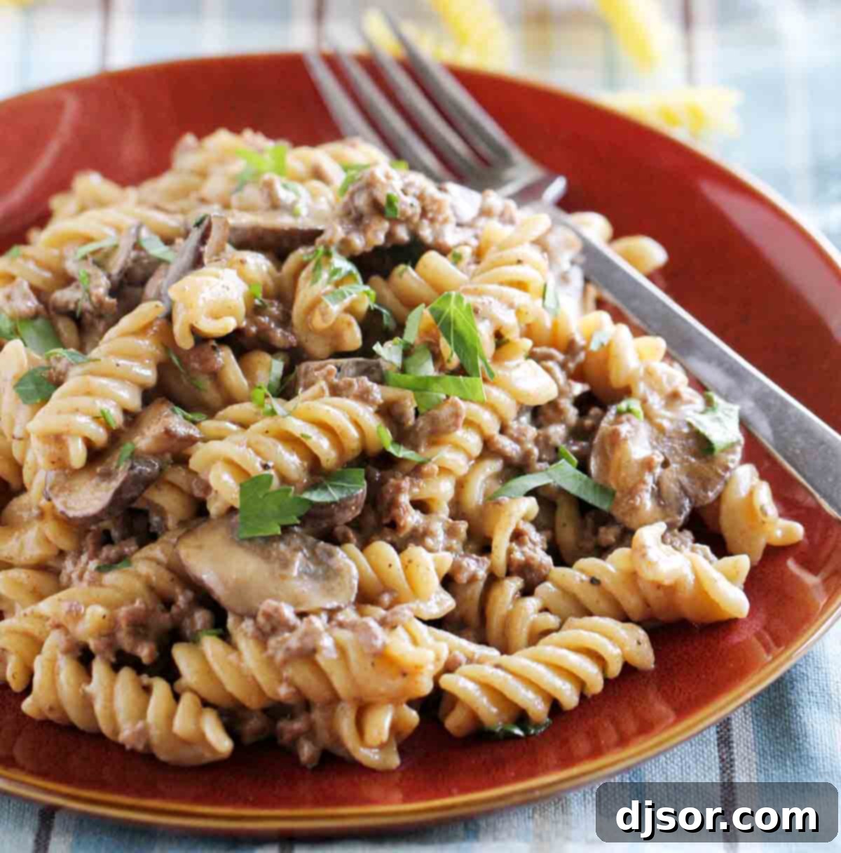 One Pot Ground Beef Stroganoff garnished with fresh parsley on a white plate