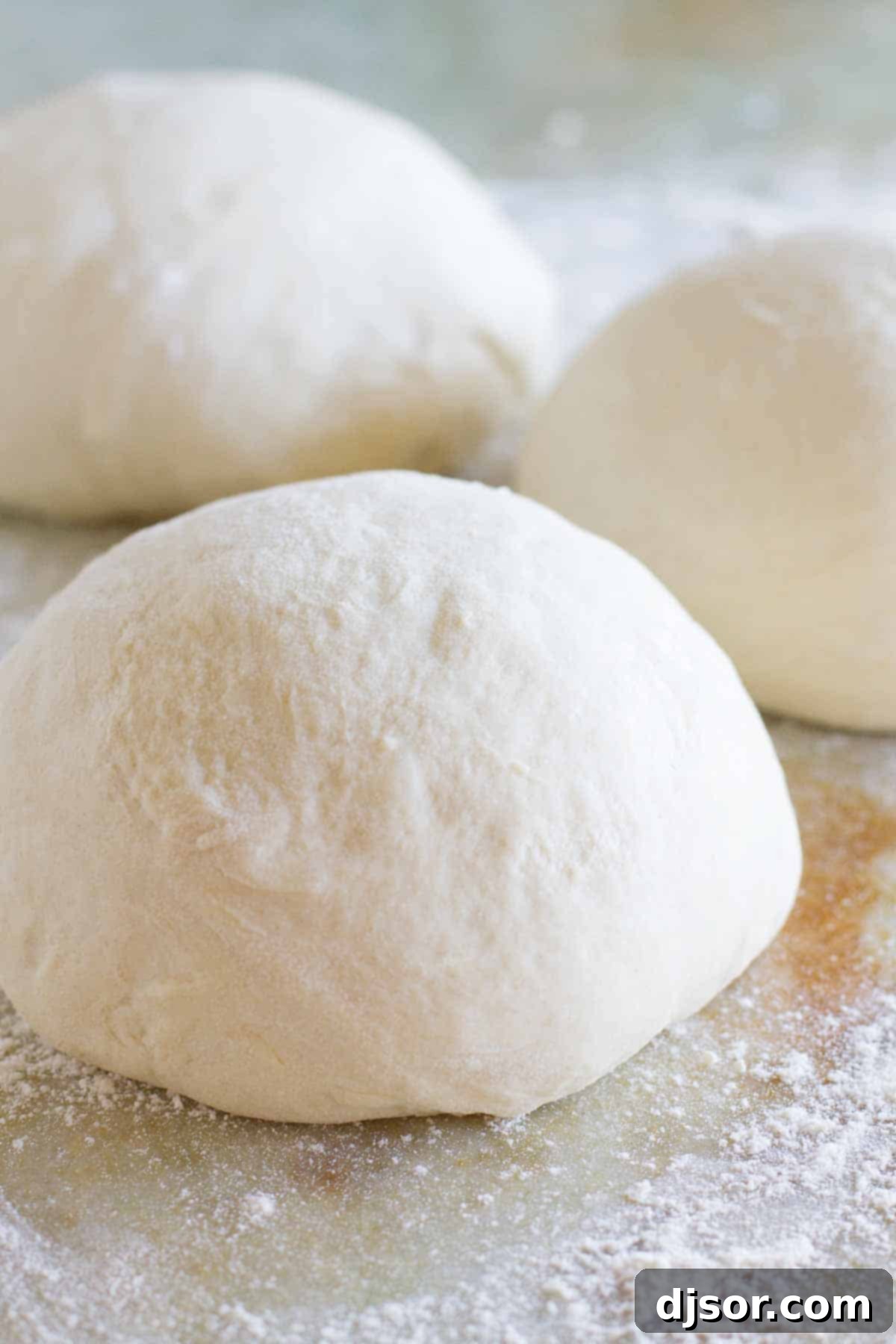 Freshly made balls of Homemade Pizza Dough dusted with flour