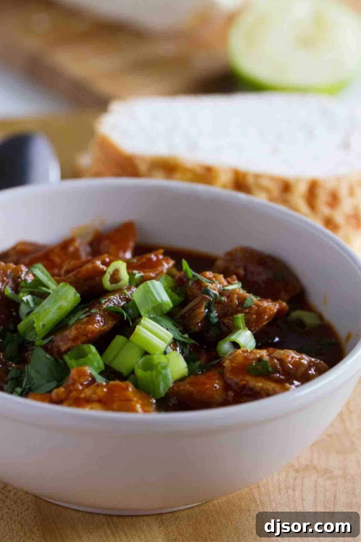 New Mexican Red Pork Chili - Tender Pork in Rich Sauce A steaming bowl of New Mexican Red Pork Chili with tender pork and a rich red sauce, garnished with fresh cilantro.