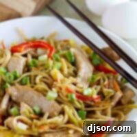shallow bowl with egg and pork lo mein with chopsticks