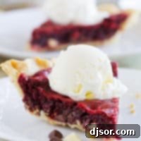 Slice of Red Velvet Cookie Pie topped with a scoop of ice cream.