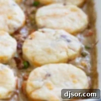 Chicken Pot Pie with Biscuits and Bacon in a white casserole dish.