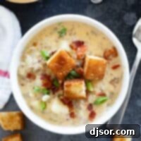 Bowl of bacon cheeseburger chowder topped with croutons and bacon.