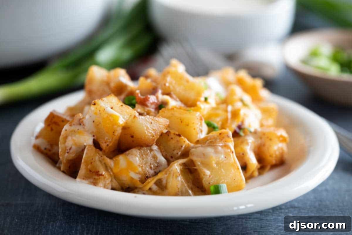Serving of Cheesy Ranch Potatoes on a plate, garnished with fresh herbs