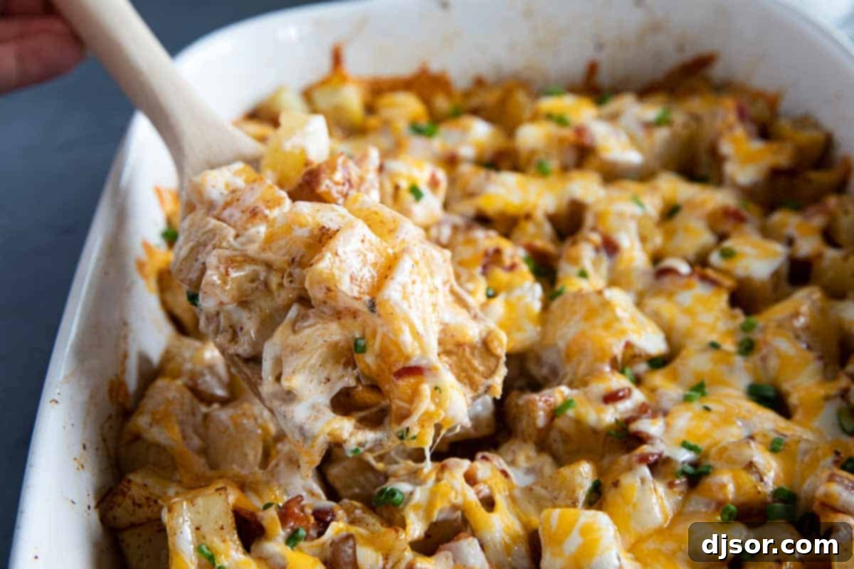 Scooping out a generous serving of Cheesy Ranch Potatoes from a baking dish