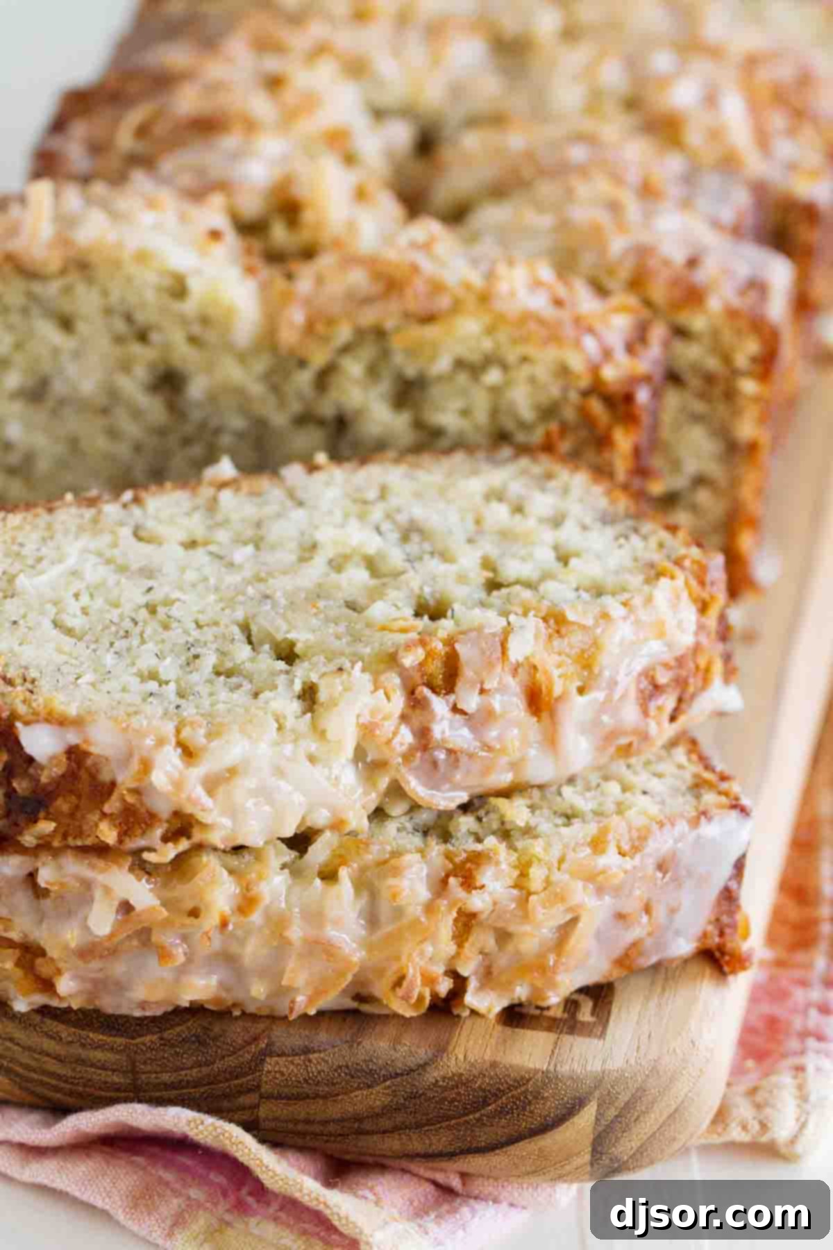 banana bread with coconut and a citrus glaze sliced and stacked