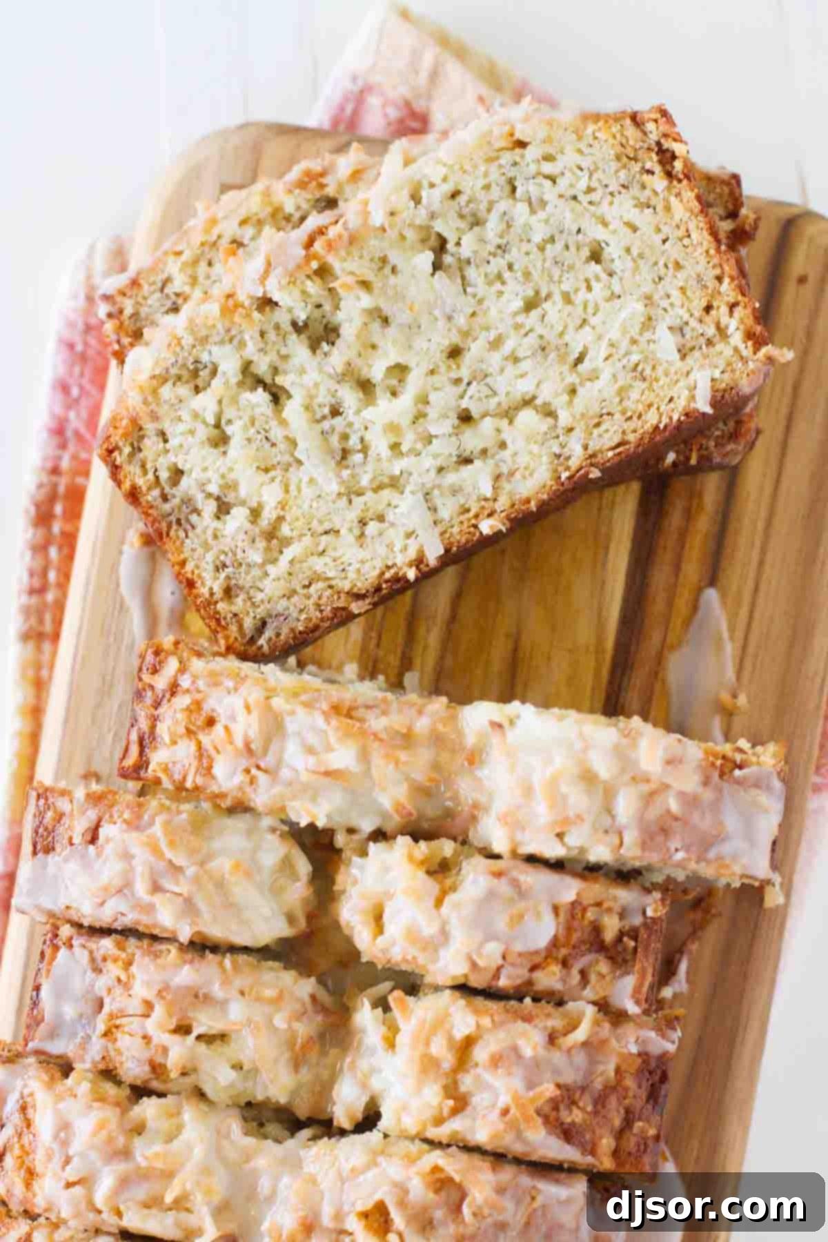 sliced loaf of Citrus Glazed Coconut Banana Bread with a slice to show texture