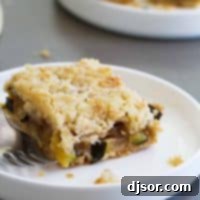 Golden Zucchini Crumble Bars 2 Zucchini Cobbler Bar on a plate with a fork, ready to be enjoyed.