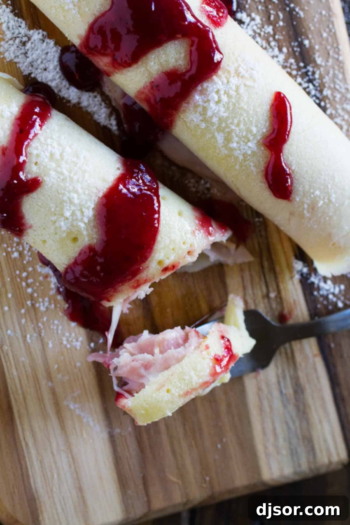 An inviting overhead view of golden Monte Cristo Crepes, ready to be enjoyed, with one piece delicately lifted by a fork, showcasing the delicious filling.