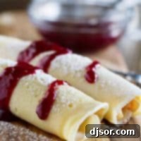 Sweet and savory Monte Cristo Crepes, featuring tender crepes filled with cheese, ham, and turkey, then topped with luscious raspberry jam and a dusting of powdered sugar. Perfect for any meal!