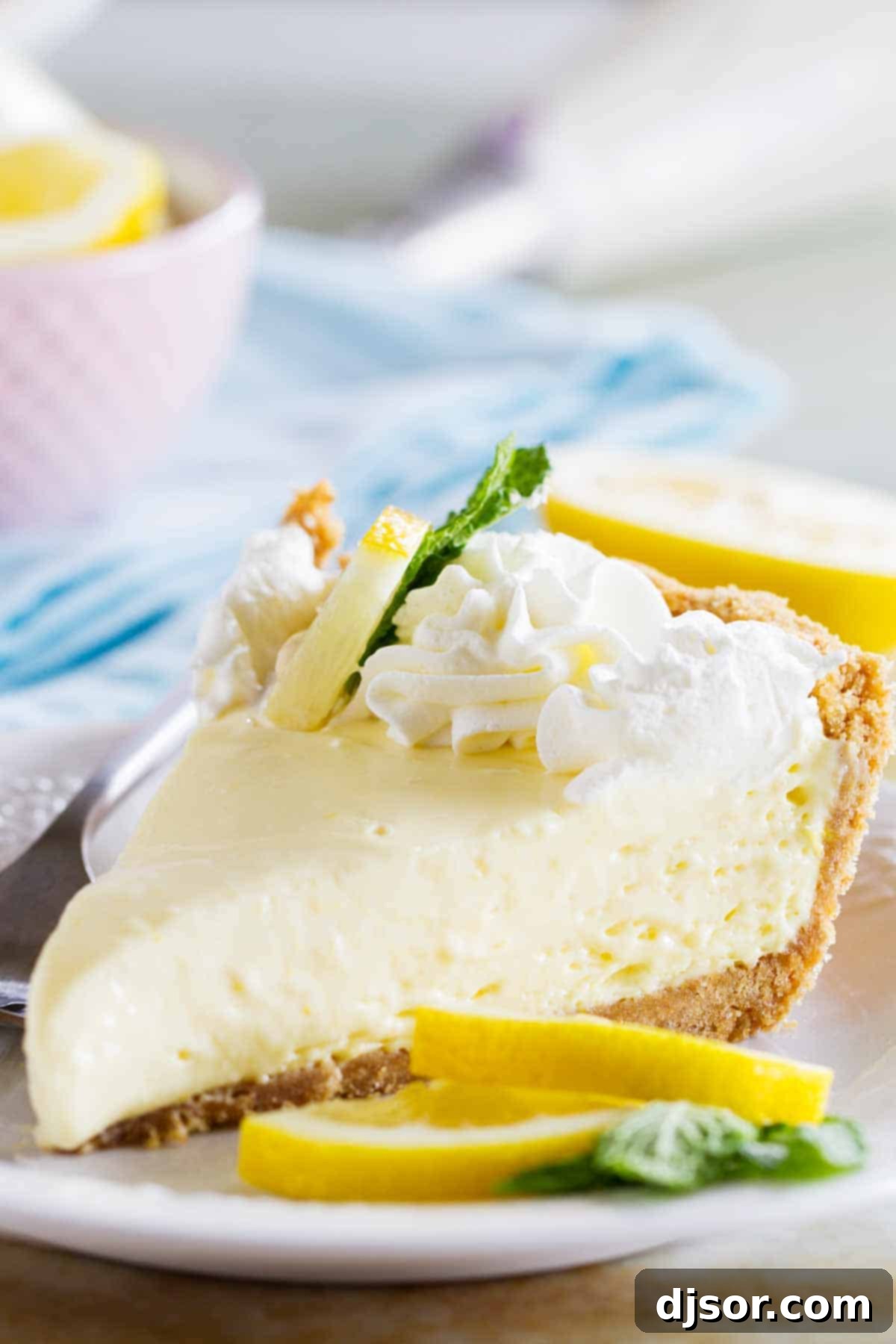 slice of lemon cream pie topped with whipped cream and lemon zest