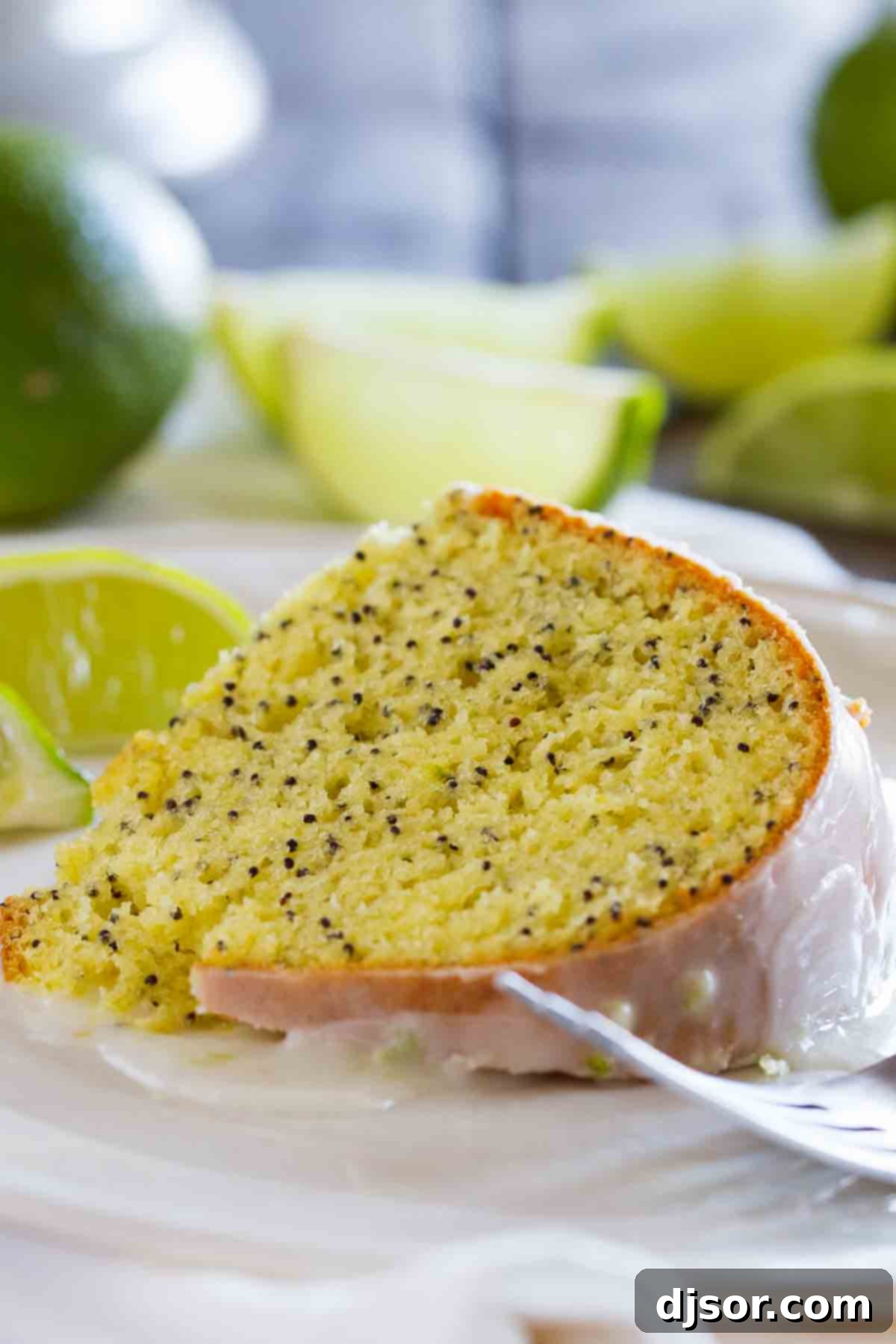 slice of Lime Poppy Seed Cake on a plate with a fork