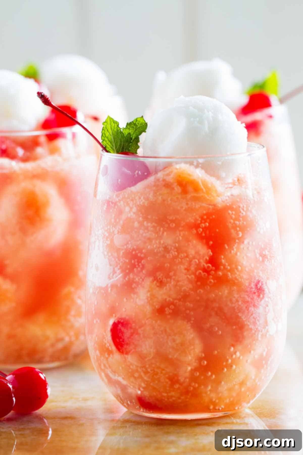 drink made with frozen fruit and topped with sorbet, presented in a clear glass