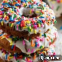 A stack of three Homemade Funfetti Donuts with colorful sprinkles.
