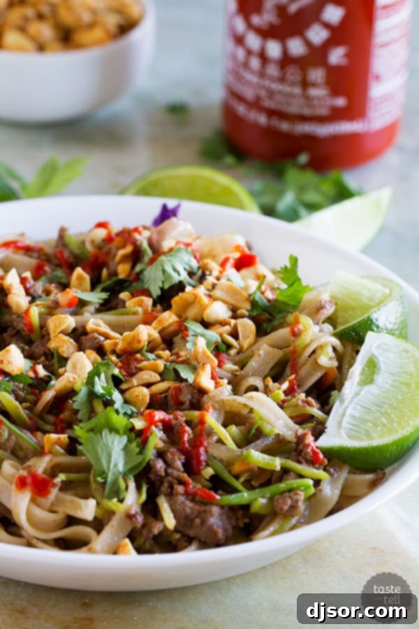 Delicious Beef Satay Noodles for an easy weeknight meal A vibrant bowl of Beef Satay Noodles, richly topped with crushed peanuts and a drizzle of Sriracha sauce, ready to be enjoyed.