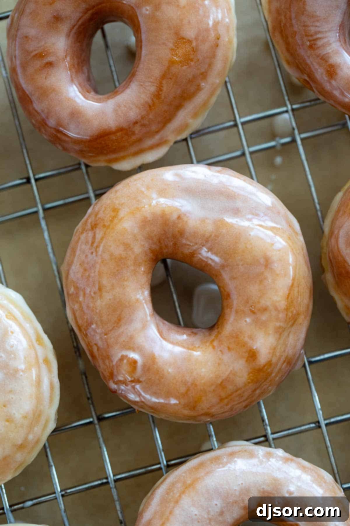 Classic Glazed Delights 8 A fresh batch of homemade Glazed Donuts neatly arranged on a cooling rack, with their glossy glaze setting beautifully.