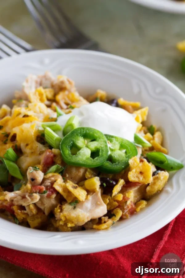 A vibrant Slow Cooker Cheesy Chicken and Frito Casserole, garnished with fresh cilantro, ready to be served. A perfect easy slow cooker dinner recipe.