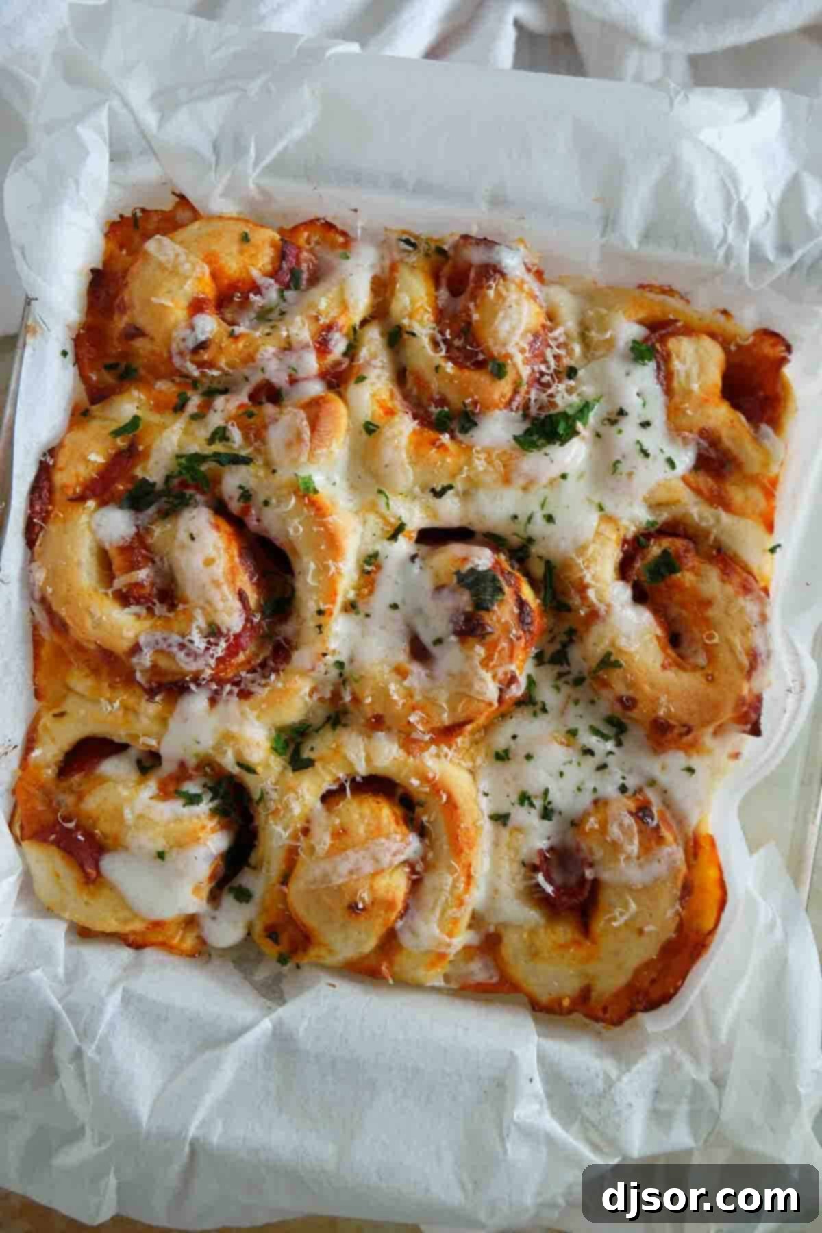Pizza rolls baked in a dish with bubbling cheese and crispy pepperoni, showcasing a delicious golden crust.