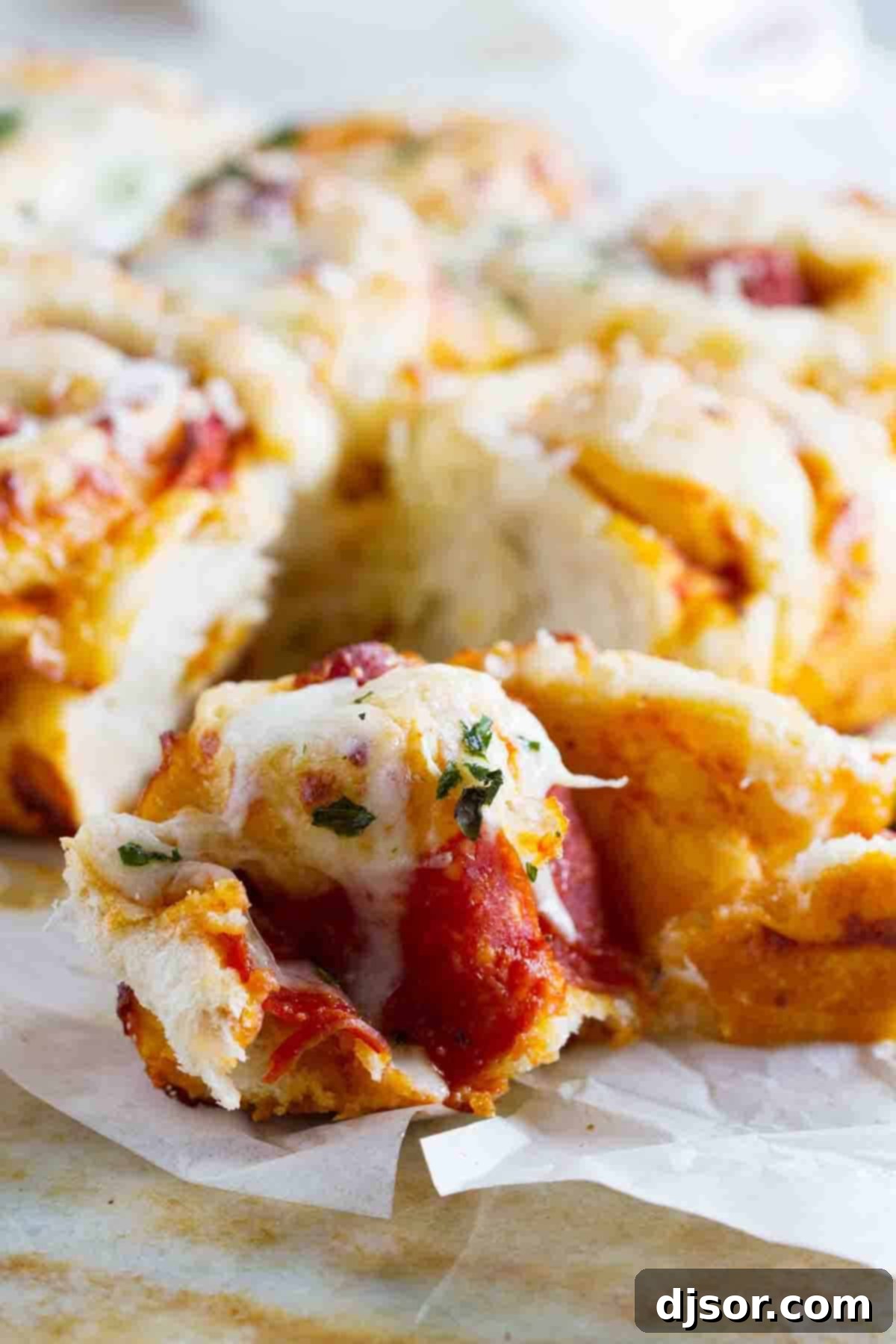 A homemade pepperoni pizza roll broken open to reveal its cheesy, pepperoni-filled interior.