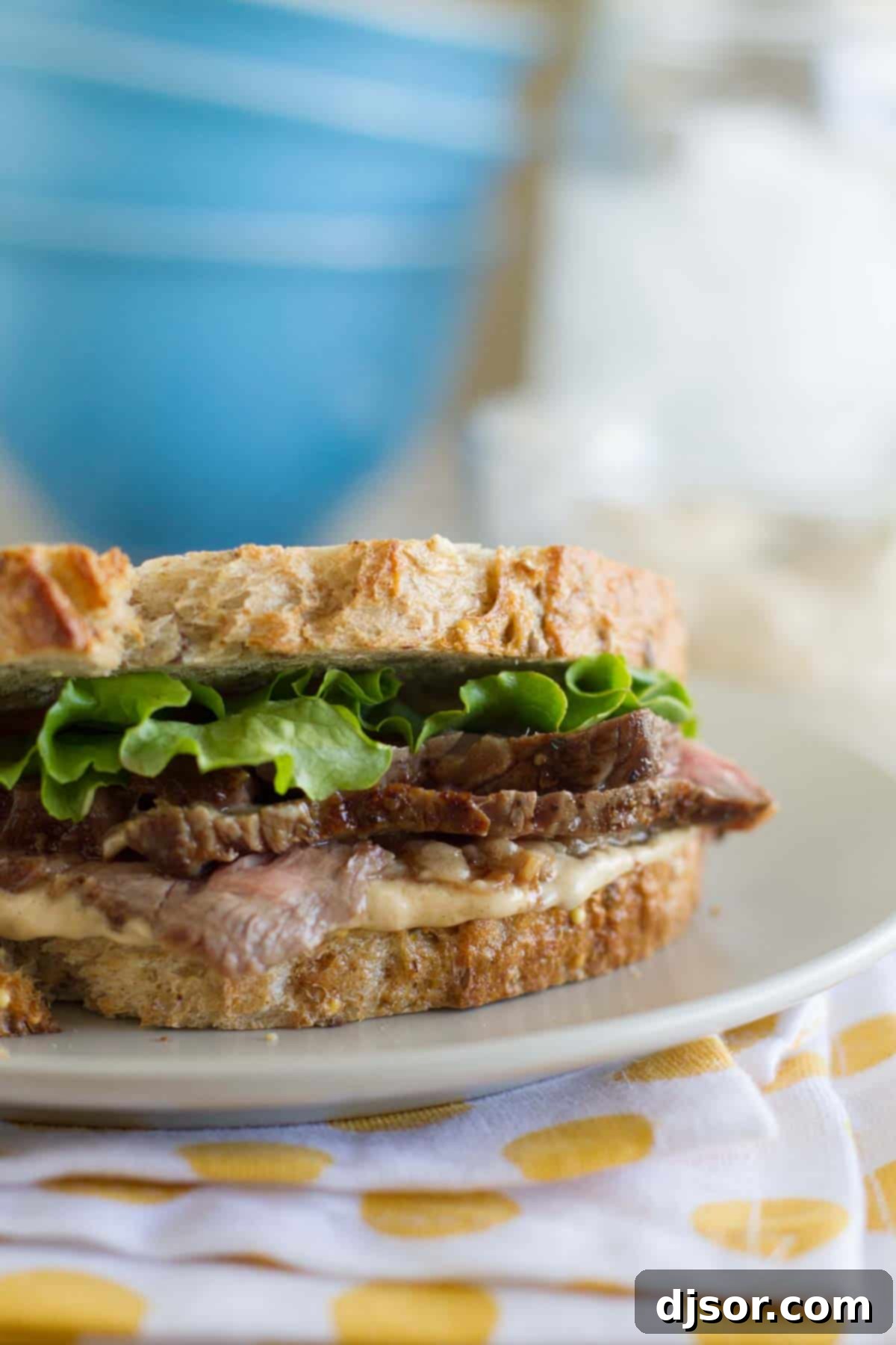 Delicious Steak Sandwich with Worcestershire Mayonnaise on whole grain bread, garnished with fresh green leaf lettuce.